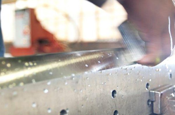 A man honing an industrial blade during the sharpening process
